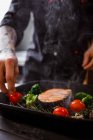 Шеф-кухар готує соковитий смажений лососевий стейк з овочами на грилі — стокове фото