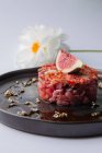 Primo piano vista di un piatto di Tartaro con salsa rossa e fichi — Foto stock