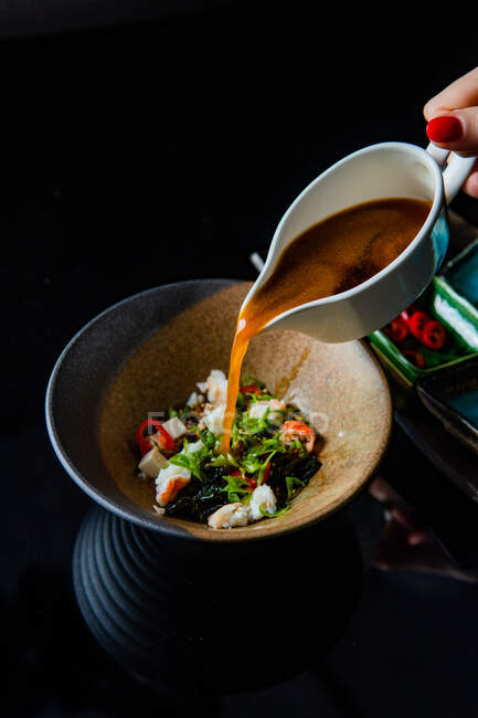 Vista ravvicinata della zuppa gourmet con ingredienti in tavola — Foto stock