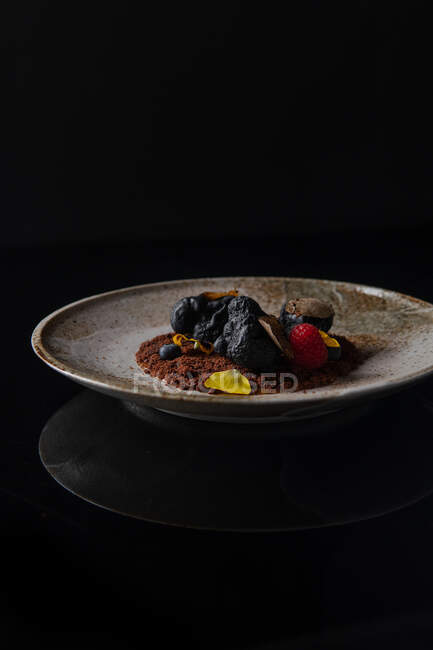 Chocolate truffles with nuts and berries on black background — Stock Photo