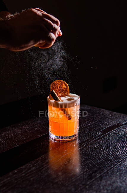 Alcoholic cocktail in a glass with ice cubes on black background — Stock Photo