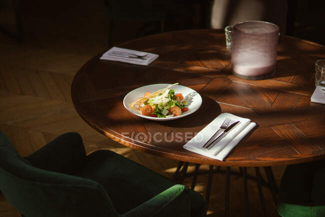 Vista de cerca de la deliciosa ensalada César con camarones en la mesa en el restaurante - foto de stock