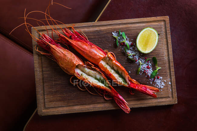 Fresh shrimps with salt and lime served with lemon and herbs — Stock Photo