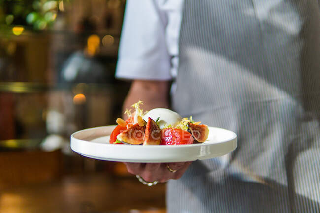 Colpo ritagliato di chef con insalata di verdure fresche al ristorante — Foto stock