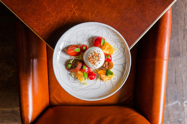Blick von oben auf köstlichen Salat mit Tomaten, Mozzarella und Basilikum auf dem Teller — Stockfoto