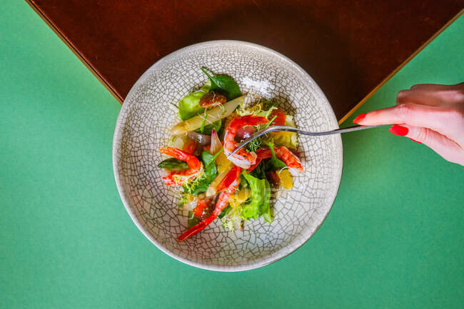 Tiro cortado de mulher comendo salada fresca gourmet com legumes e camarões — Fotografia de Stock
