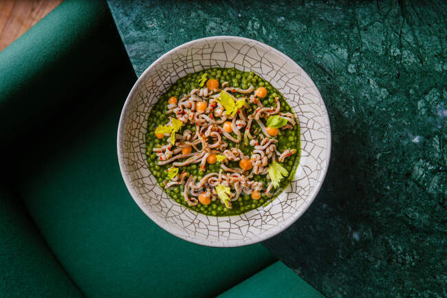 Вид зверху смачної зеленої страви з овочами в тарілці на мармуровому столі — стокове фото