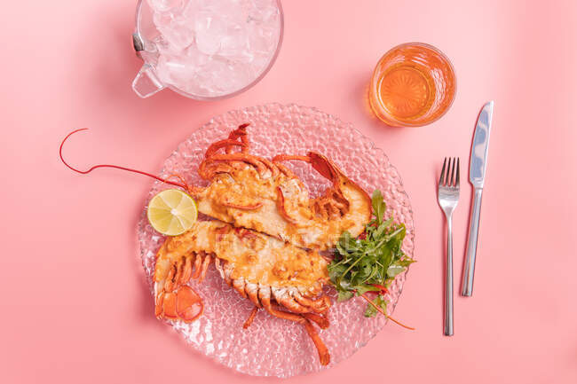 Top view of delicious cooked lobster with herbs and lemon on pink background — Stock Photo