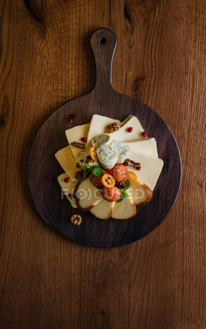 Different types of cheeses on rustic wood table top view — Stock Photo