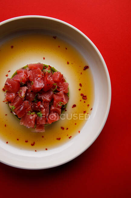 Closeup view of a plate with salmon slices on avocado puree in a sauce — Stock Photo