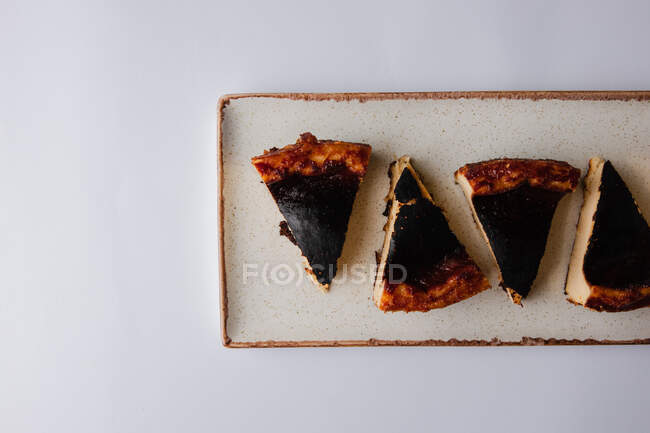 Vista superior de deliciosas rebanadas de pastel de queso de chocolate en un plato blanco - foto de stock