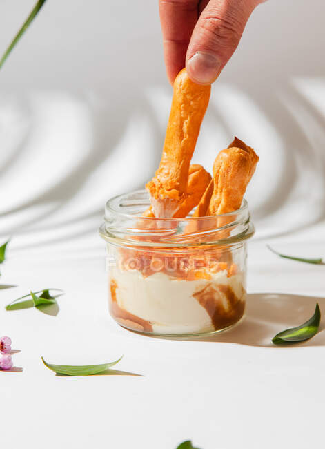 Closeup view of eclairs with cream in jar — Stock Photo