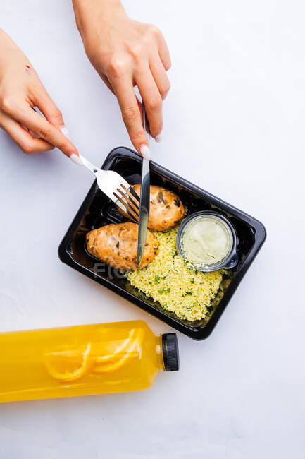Вид на обеденную коробку с кускусом и мясом на белом фоне — стоковое фото