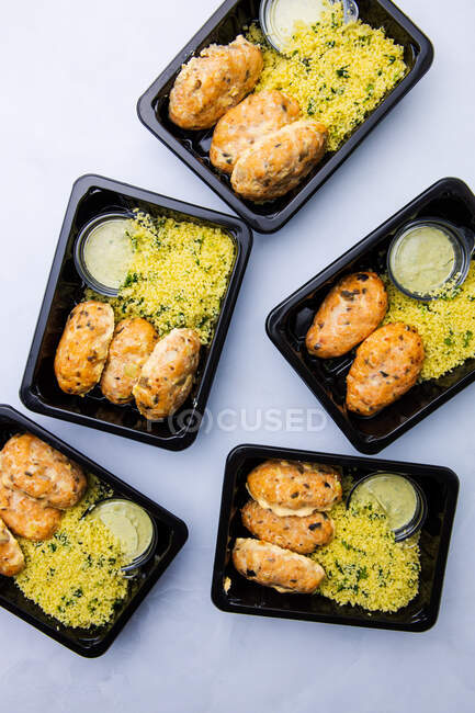 Vue du dessus des boîtes à lunch avec couscous et viande sur fond blanc — Photo de stock