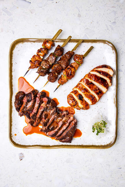 Vista superior de la deliciosa carne frita en salsa, rebanadas de carne de kebabs y filete de pollo con corteza - foto de stock