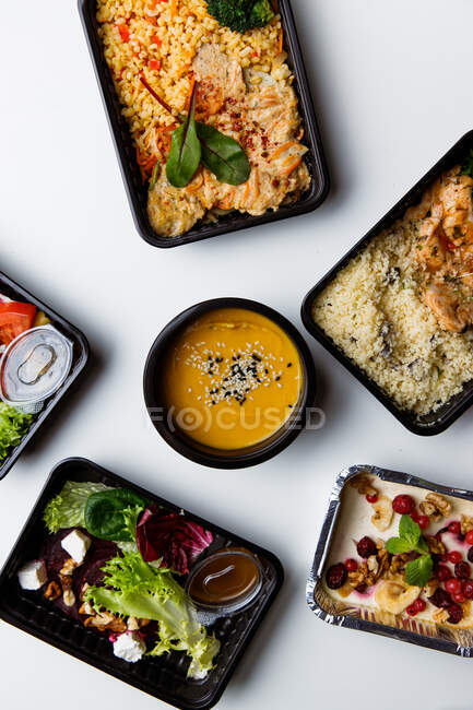 Vista superior de um tipo diferente de comida saudável em utensílios de mesa descartáveis — Fotografia de Stock