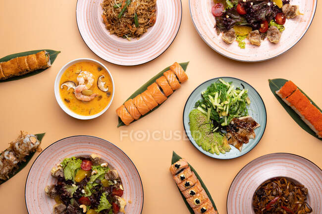 Набір мисок різних страв з овочами та тарілками з соусами — стокове фото