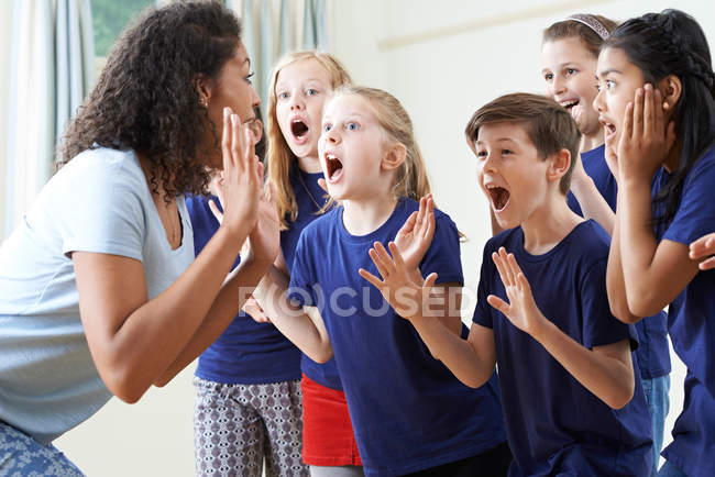 Kindergruppe mit Lehrer genießt gemeinsamen Schauspielunterricht — Stockfoto