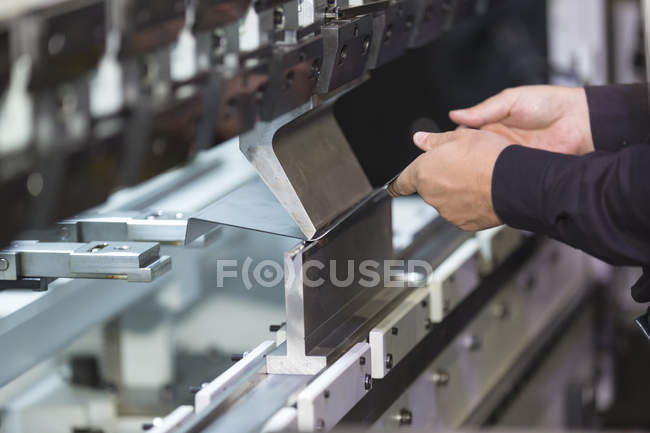 Operador doblando la hoja de metal por la máquina dobladora de hoja - foto de stock
