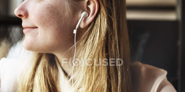 Fille écouter de la musique dans les écouteurs — Photo de stock