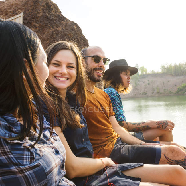 Freunde sitzen am See — Stockfoto