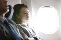 Uomini d'affari cinesi che dormono in volo — Foto stock