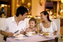 Chinese family with daughter dining at restaurant — Stock Photo