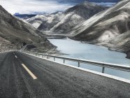 Estrada sinuosa e lago nas montanhas do Tibete, China — Fotografia de Stock