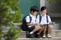 Ragazzo e ragazza cinese che studiano sul portico — Foto stock