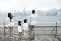 Вид сзади семьи, наслаждаясь пейзажами Виктория-Харбор, Гонконг — стоковое фото