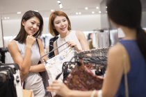 Female friends shopping in clothing store — Stock Photo