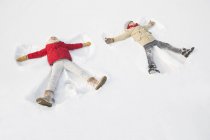 Bambini cinesi che fanno angeli di neve — Foto stock