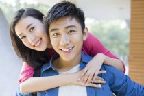 Chinese couple embracing on street and looking in camera — Stock Photo