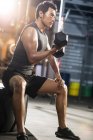 Chinese stemmt Gewichte im Fitnessstudio — Stockfoto