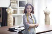 Female asian fashion designer in studio with crossed arms — Stock Photo