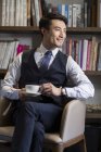 Азиатский бизнесмен пьет кофе в учебе — стоковое фото