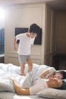 Chinês menino acordar pais no quarto — Fotografia de Stock