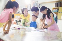 Enfants chinois peignant en classe d'art avec professeur — Photo de stock