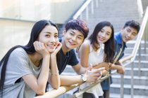 Chinese woman standing together with friends on stairs — Stock Photo