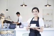 Cameriera cinese caffetteria in piedi con una tazza di caffè — Foto stock