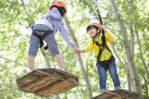 Chinesische Kinder klettern im Abenteuerpark auf Bäumen — Stockfoto