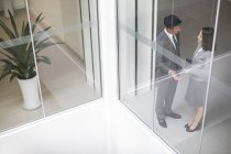Les gens d'affaires chinois parlent dans un immeuble de bureaux — Photo de stock