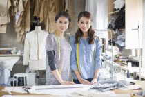 Chinese female fashion designers standing at table — Stock Photo
