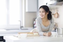 Mulher asiática bebendo café na cozinha — Fotografia de Stock
