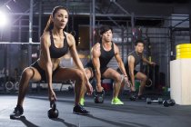 Chinese athletes training with kettlebells in crossfit gym — Stock Photo
