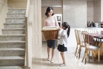 Chinese daughter helping mother doing laundry at home — Stock Photo