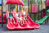 Niños chinos deslizándose en el parque de atracciones - foto de stock