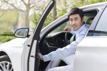 Asiático hombre apertura puerta en coche - foto de stock
