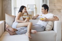 Cinese coppia avendo colazione su divano — Foto stock