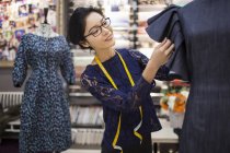 Créatrice de mode chinoise travaillant sur la robe en magasin — Photo de stock